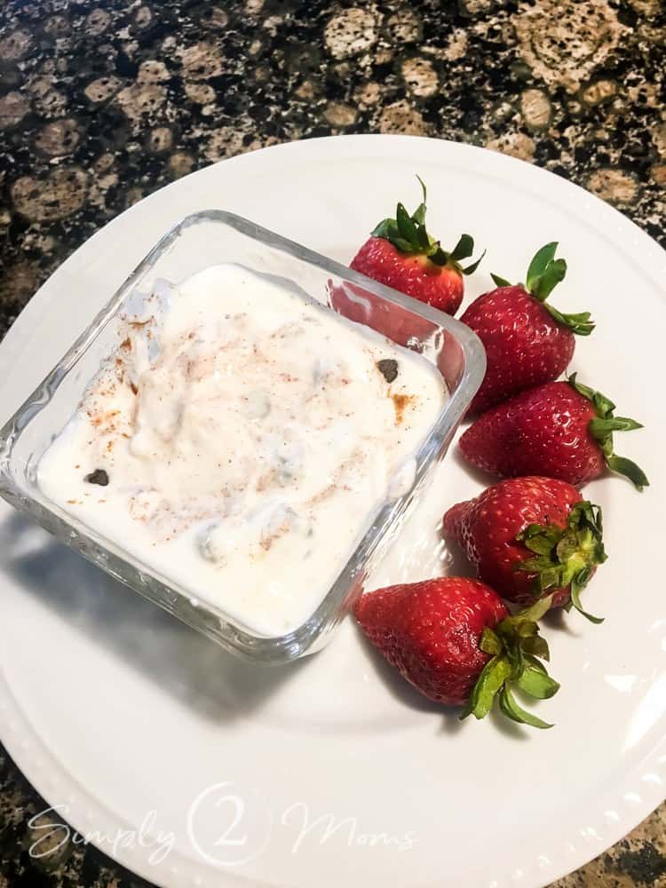 plate with bowl of low carb cannoli cream with whole strawberries