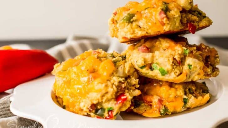stack of keto southwest breakfast biscuits on a scalloped plate garnished with mini bell peppers
