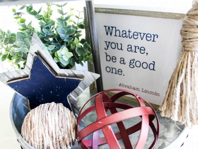 bottom of tray decorated with plant, star, twine orb, metal red orb, and quote sign