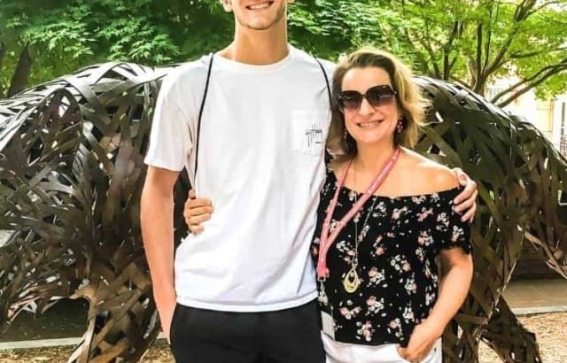 mom and son standing in front of NC State wolfpack statue