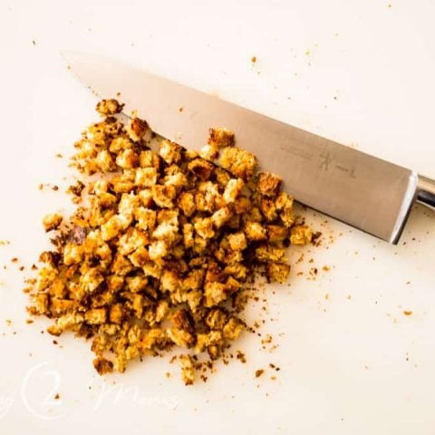 slice of grilled toast chopped into small crumbs with a knife