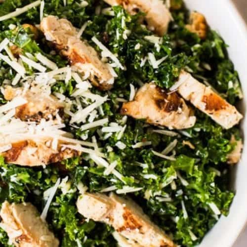 overhead view of a bowl of kale salad topped with chicken