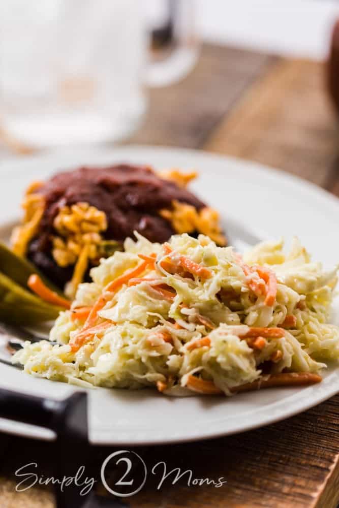 plate with low carb coleslaw, pickled okra, and burger topped with pimento cheese and keto bbq sauce