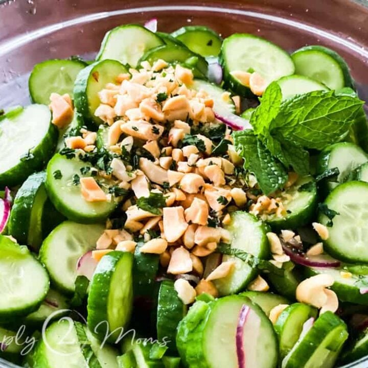 overhead view of glass bowl filled with Vietnamese cucumber salad garnished with chopped peanuts and fresh mint