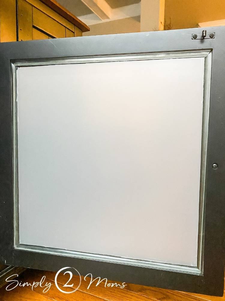 Inside view of a glass cabinet door with frosted window film applied and trimmed