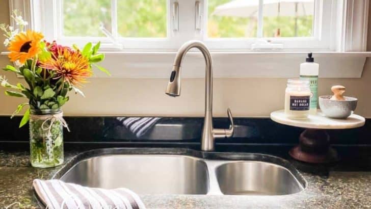 view of kitchen sink with window above and flowers next to sink