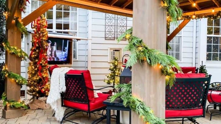 Outdoor pergola decorated for Christmas with posts wrapped with Christmas garland