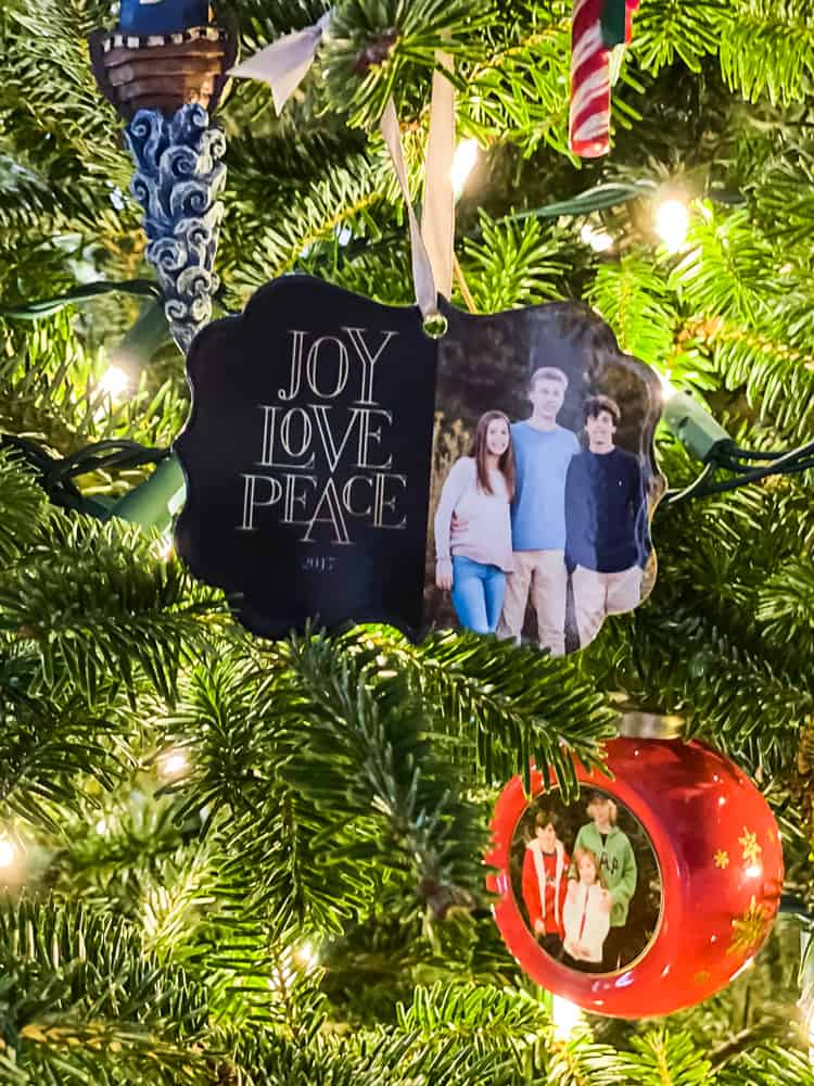 close up of personalized photo ornament hanging on Christmas tree