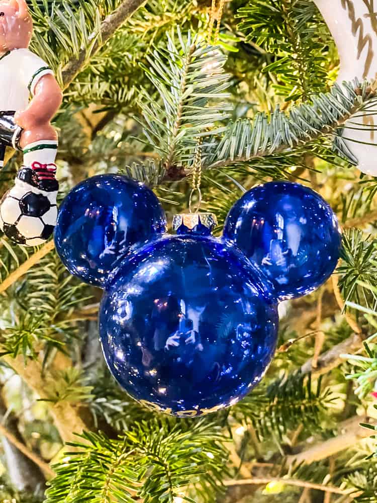 mickey mouse glass ornament hanging on decorated Christmas tree
