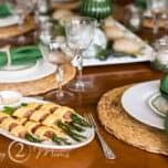 Plate of low carb Ham Asparagus Twists on a wood table with white dinnerware and green napkins
