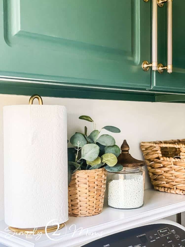 Shelf over washer and dryer with laundry room essentials and faux plants