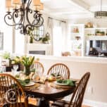 Cherry wood kitchen table with French country chandelier decorated for spring with natural elements