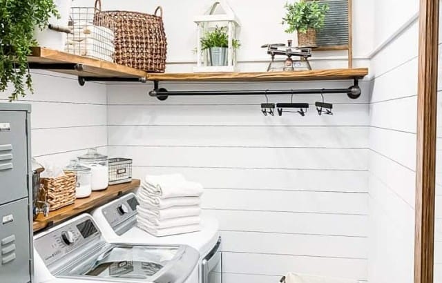 laundry room transformation with shiplap walls diy wood shelving and plumping pipe hanging rod industrial lighting from ceiling lockers and appliance on left side of room