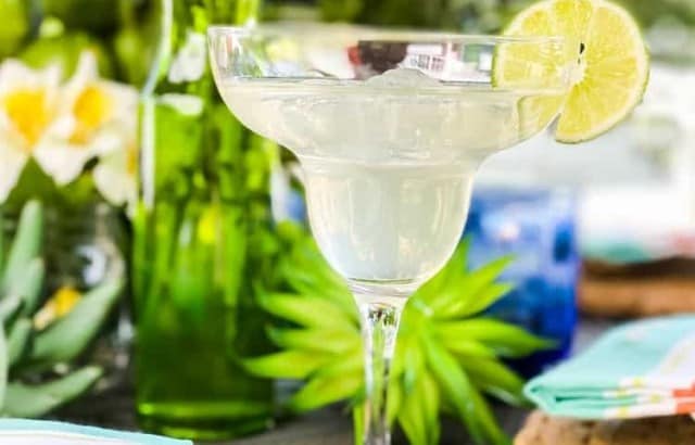 close up of margherita glass filled with drink and lime slice on fiesta tablescape