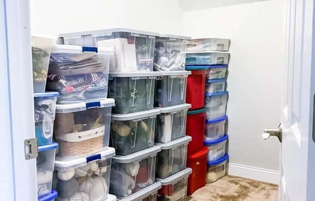 completed storage closet makeover with plastic storage bins lining left side of walk-in closet