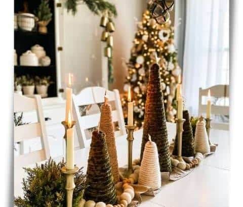 centerpiece on dining room table with table runner and yarn trees with candles between christmas tree in corner of room