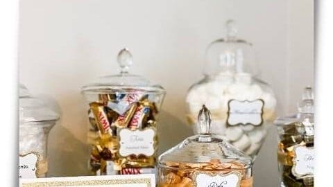 gold and white themed candy buffet in glass apothecary jars feature image