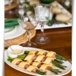 Asparagus bundles wrapped in ham and keto pastry on a plate for Easter dinner.