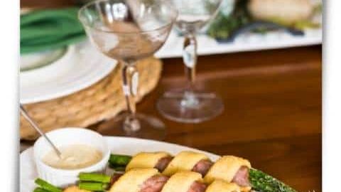 Asparagus bundles wrapped in ham and keto pastry on a plate for Easter dinner.