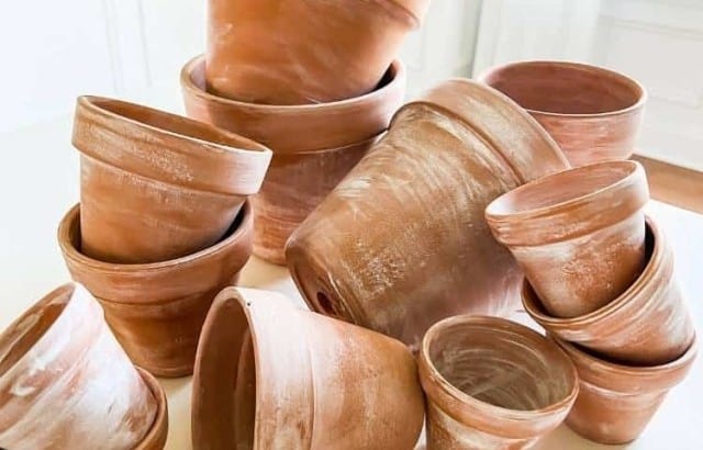 completed aged terra cotta clay pots stacked on table