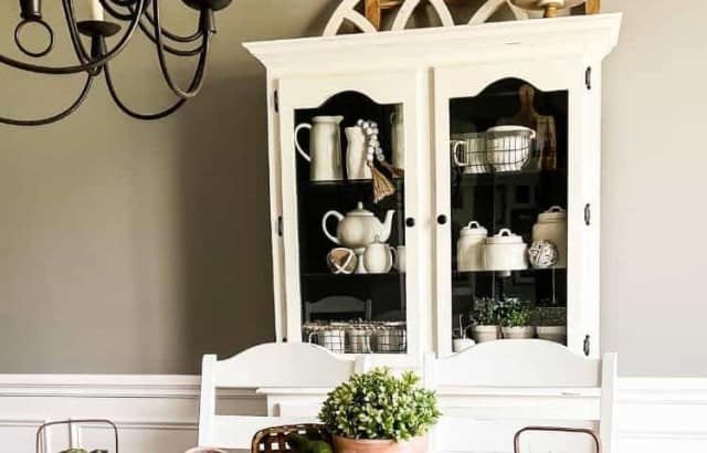 spring Easter centerpiece in middle of dining table with china hutch against wall