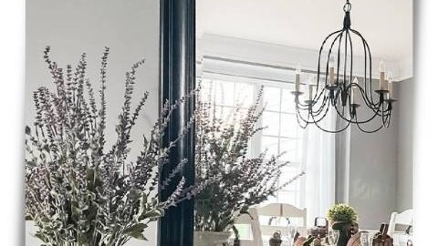 buffet table with mirror leaning against wall with faux lavender stems in vase