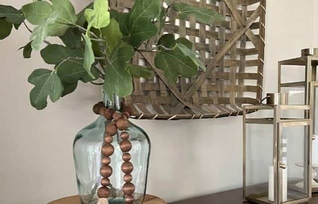 fiddle leaf stems in glass bottle with wood prayer beads hanging around jar