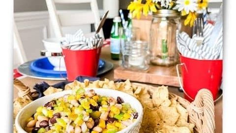 Bowl of Carolina Caviar surrounded by tortilla chips on a table set for a summer dinner party