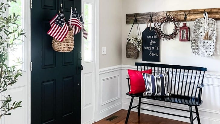 Foyer decorated for summer with American flags in a door basket and patriotic decor.
