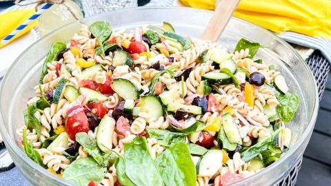 Bowl filled with a healthy Mediterranean pasta salad with lots of fresh vegetables
