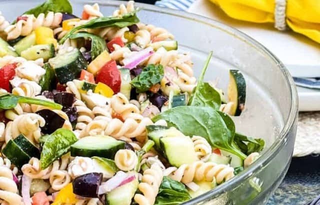 Bowl filled with a Dreamfields Greek pasta salad with lots of fresh vegetables