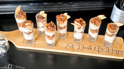 Shot glasses filled with keto caramel apple cheesecake parfaits on a custom wood board from PNW Farmhouse Design Co.