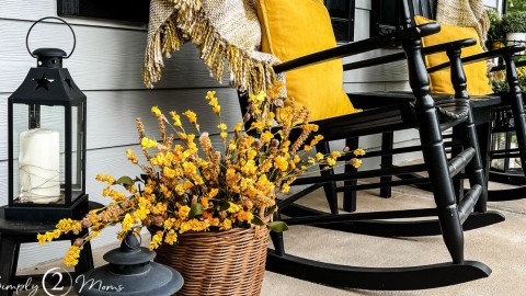 Rocking chair porch decorated for early fall with yellow throw pillows on the rockers and faux yellow flowers in a basket.