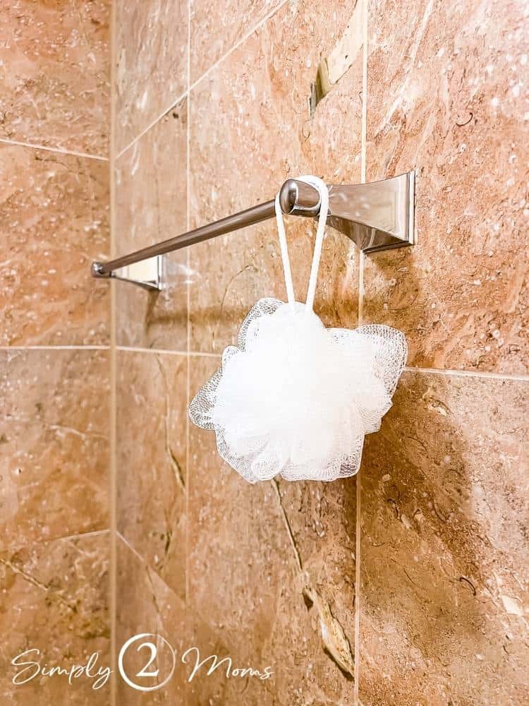 small white body pouf hanging on towel bar in hotel room