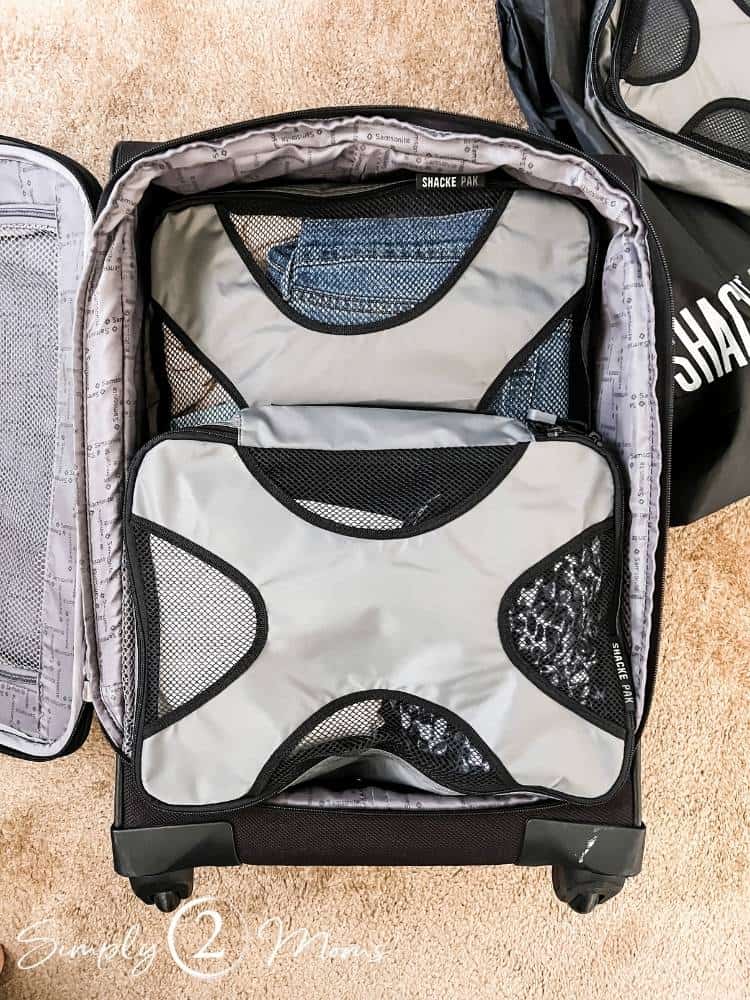 packing cubes filled with clothing in carry on suitcase