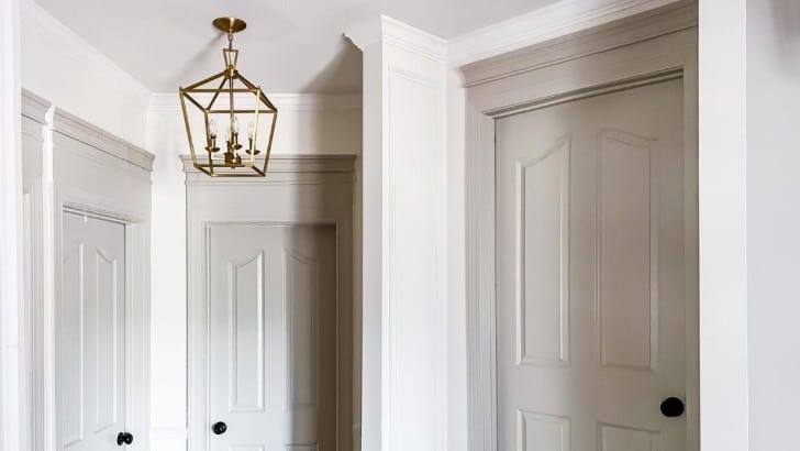 Hallway with White Dove walls and Revere Pewter doors with custom door headers.