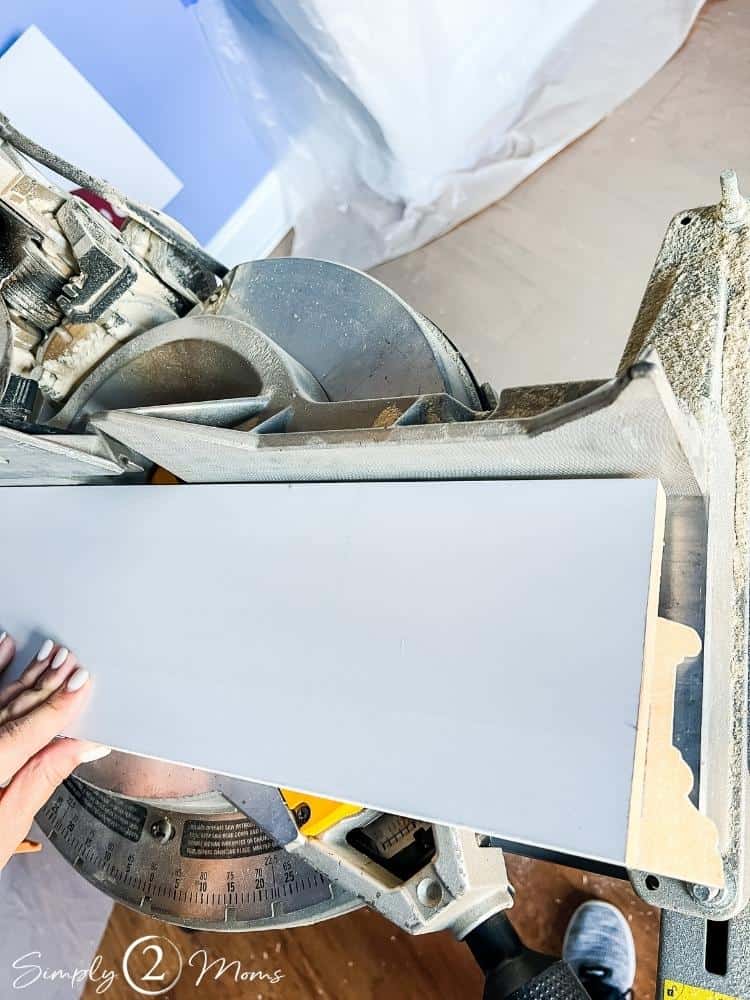 Window casing trim with the ends cut at a 45-degree angle and a board on top to measure the next cut.