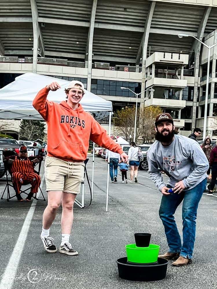 Two young men playing BulziBuckets at a college football tailgate.
