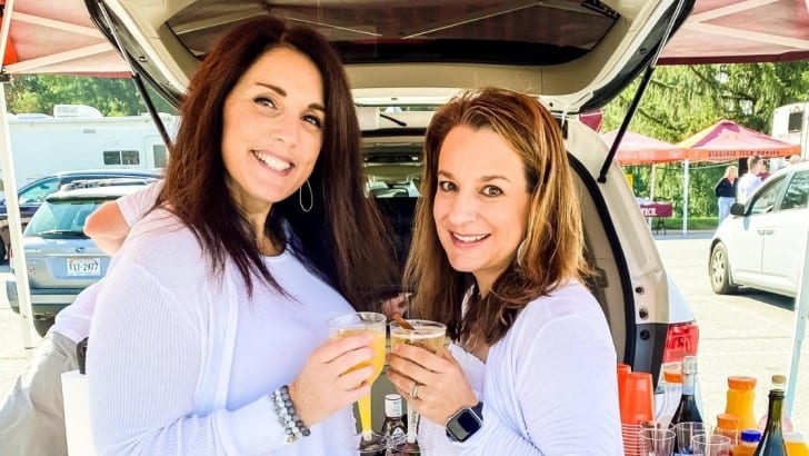 Simply2Moms toasting with mimosas at a college football tailgate party.
