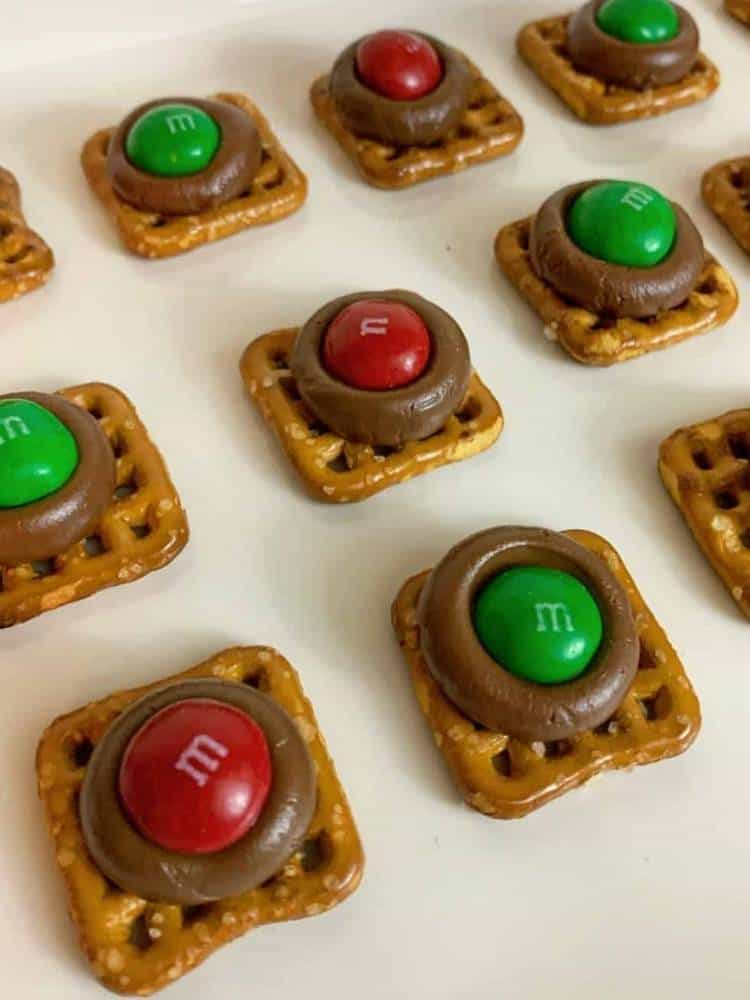 square pretzels with melted chocolate and m&m on top