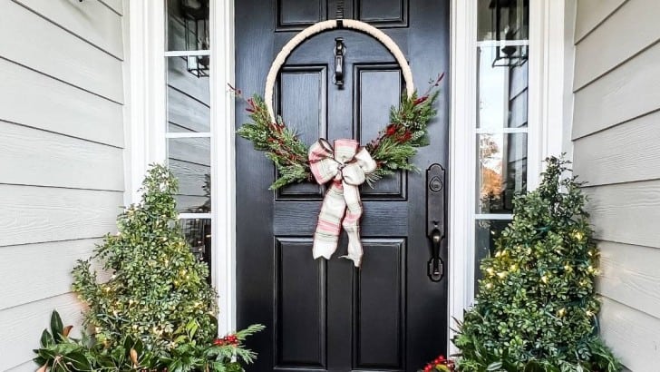 diy wreath made of yarn and greenery on front door