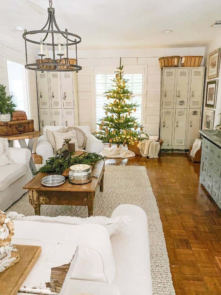 Farmhouse living room decorated for Christmas with greenery and a Noble fir Christmas tree.