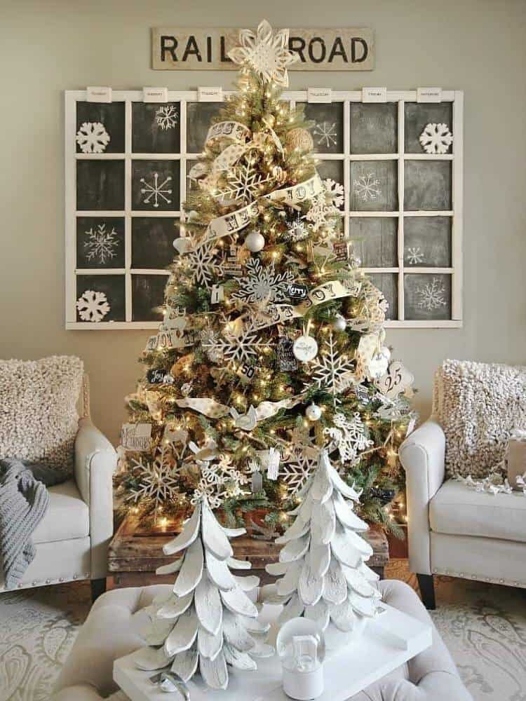 Full Christmas tree decorated with ribbon and neutral DIY ornaments.