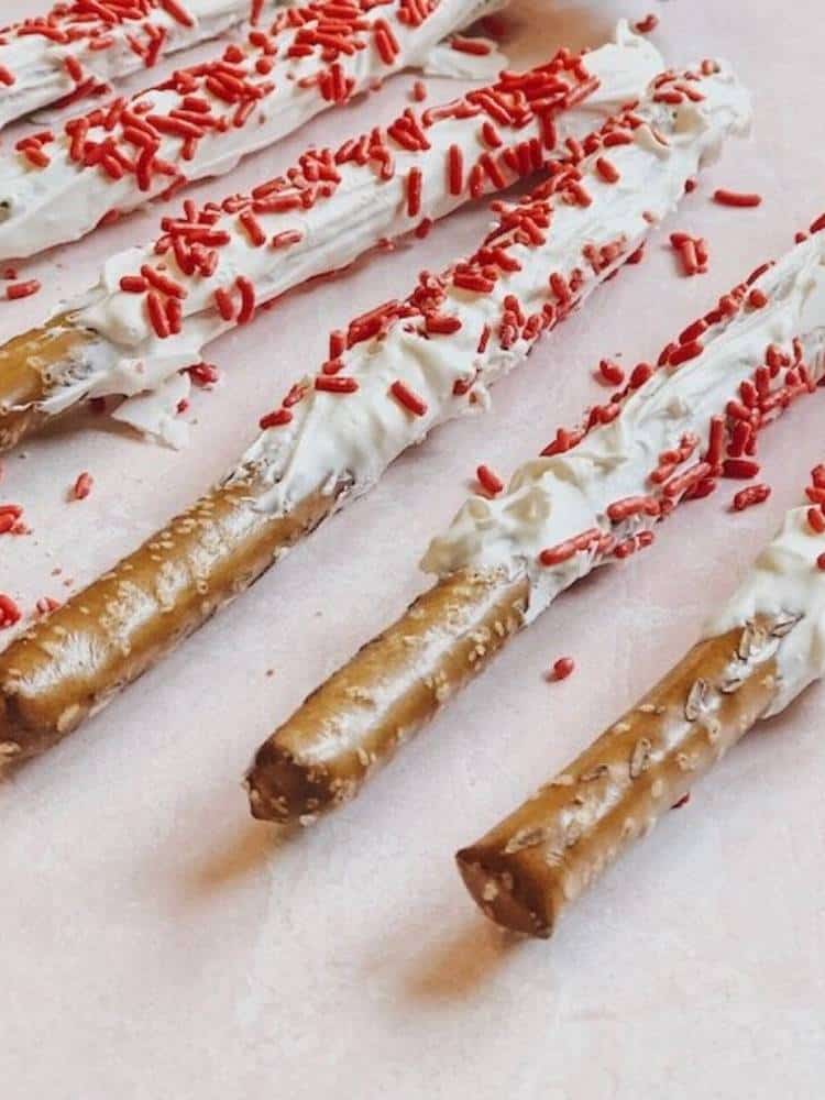 white chocolate dipped pretzels with red sprinkles