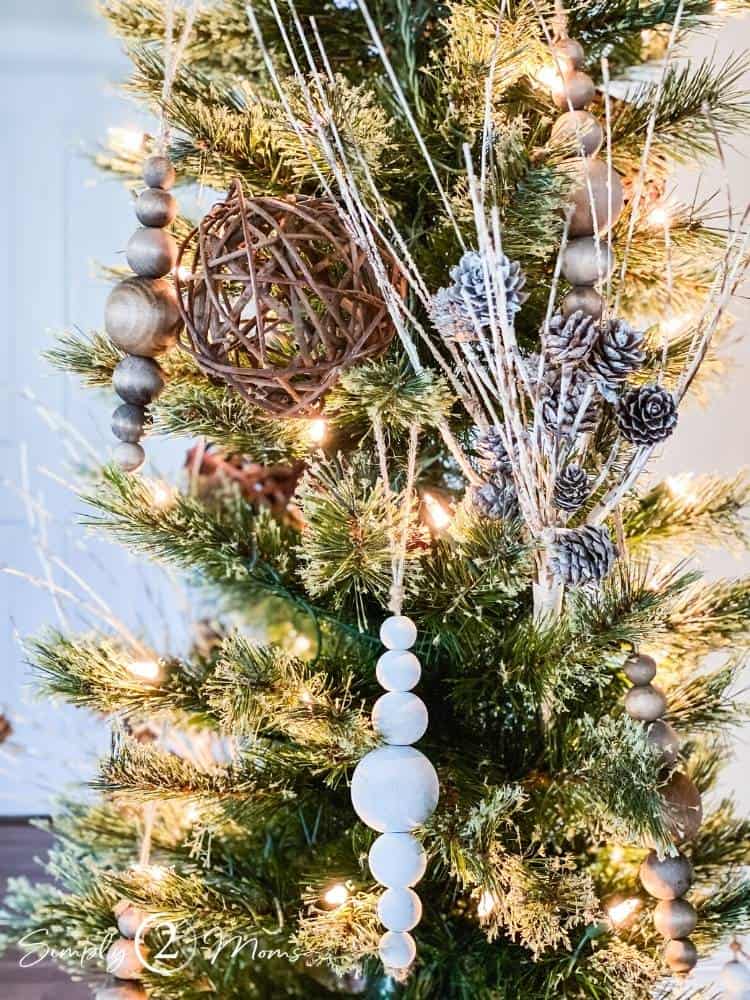 Close-up view of a narrow Christmas tree decorated with DIY wooden bead ornaments.