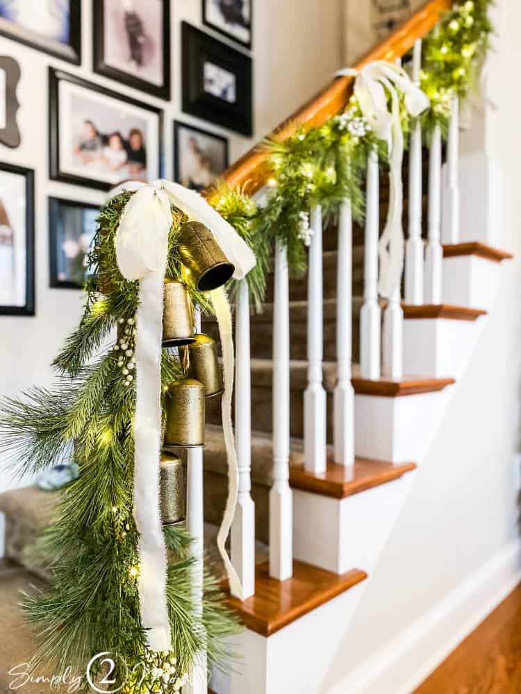 stair railing with garland and white droopy ribbons