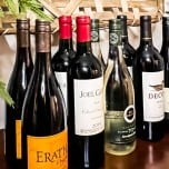 eight wine bottles lined up on top of side buffet table