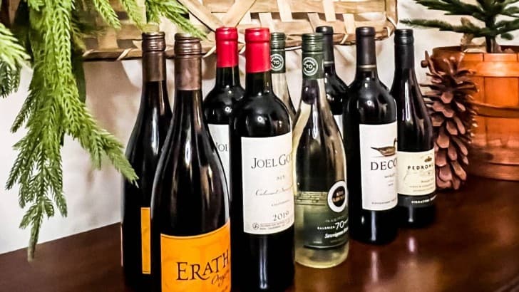 eight wine bottles lined up on top of side buffet table