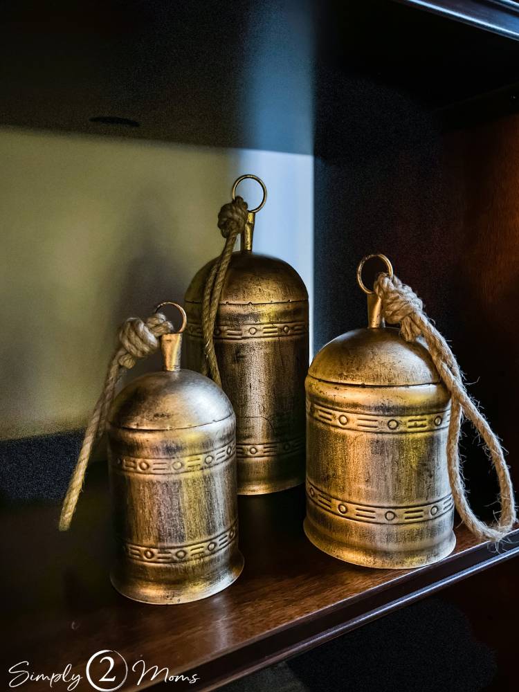 set of three large gold bells with rope handles