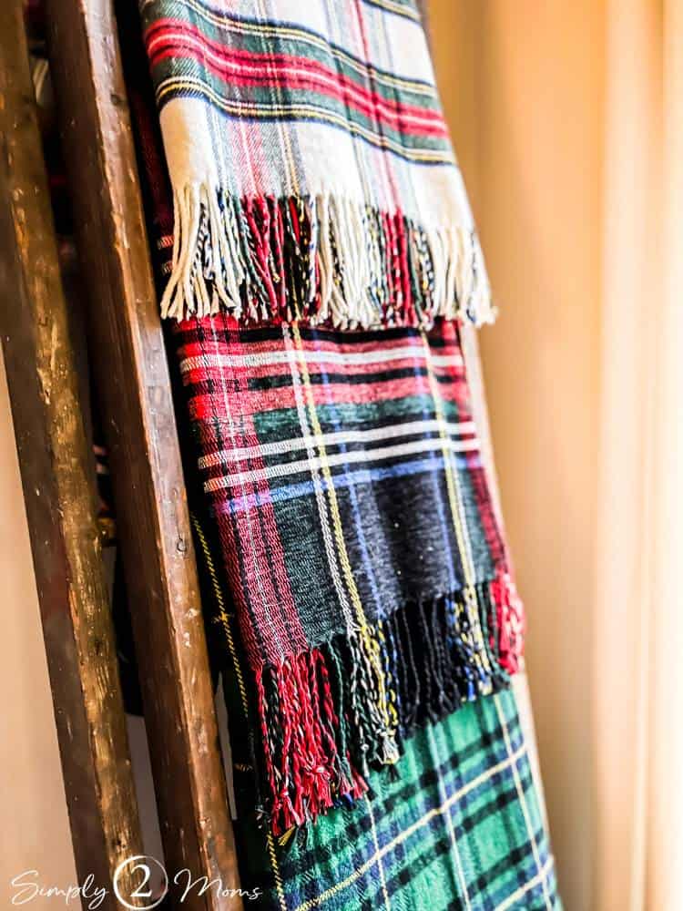 tartan plaid throws in Christmas colors hanging on antique ladder